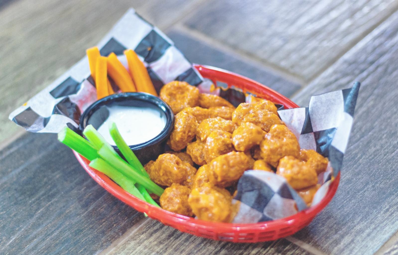 Students practicing knife techniques in well-equipped teaching kitchen
