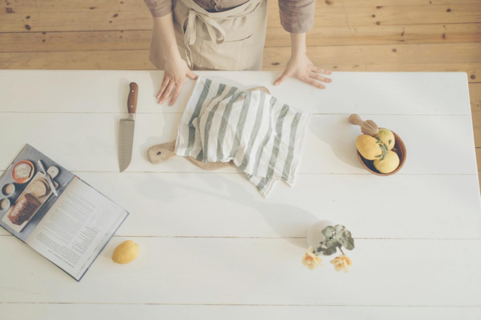 Hands kneading bread dough on a floured wooden surface